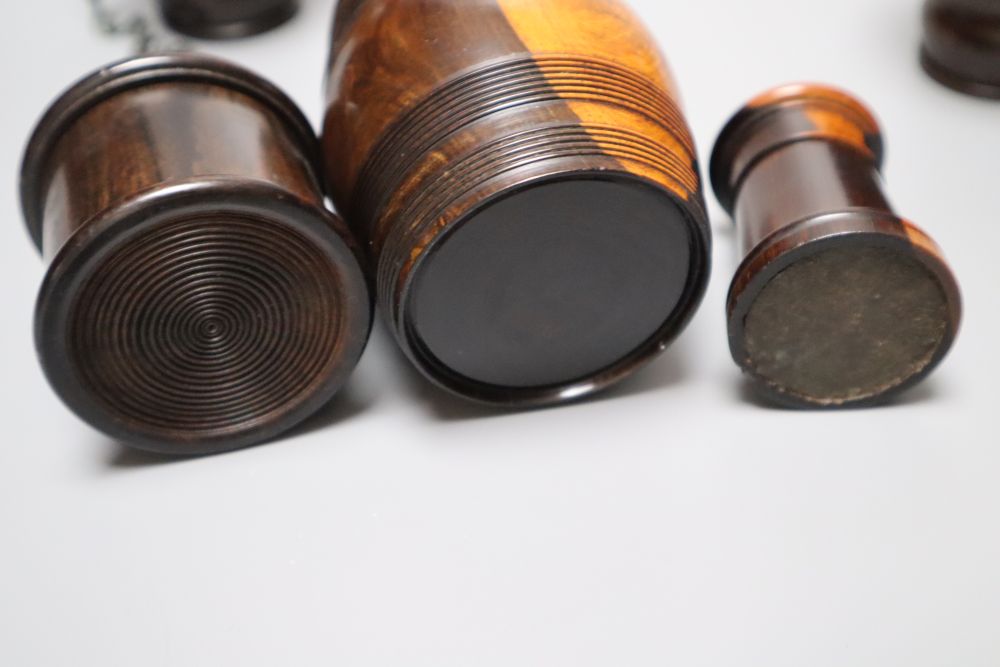 A group of 19th century lignum vitae objects: A pair of whistles and holsters, a match holder with go-to-bed, a model barrel, 9cm, a ga